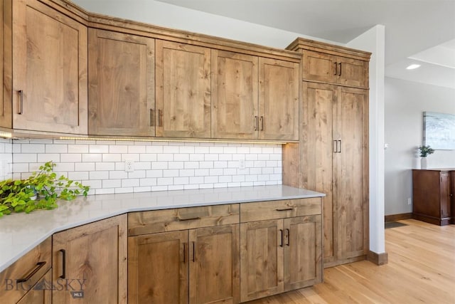 3483 Highline Rd, Manhattan, MT 59741 - kitchen with brown cabinetry, light wood finished floors, decorative backsplash, baseboards, and recessed lighting