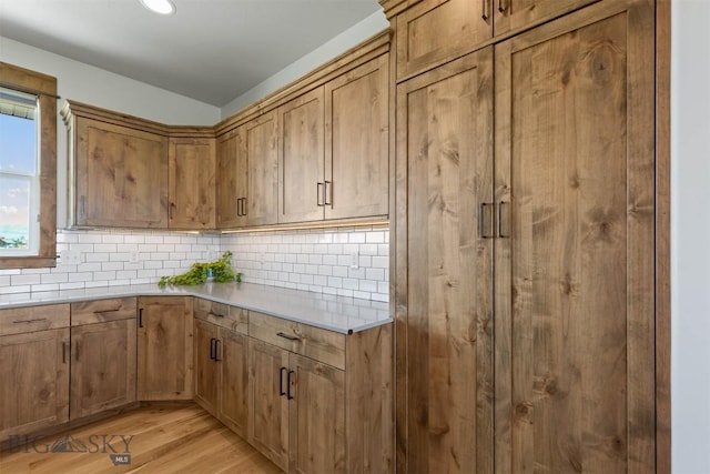 3483 Highline Rd, Manhattan, MT 59741 - kitchen with light wood-style flooring, backsplash, light countertops, brown cabinetry, and recessed lighting