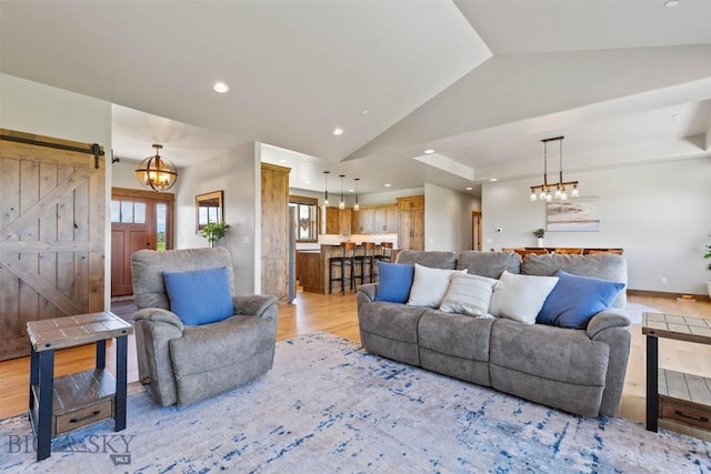 3483 Highline Rd, Manhattan, MT 59741 - living room featuring a barn door, vaulted ceiling, light wood-type flooring, recessed lighting, and a chandelier