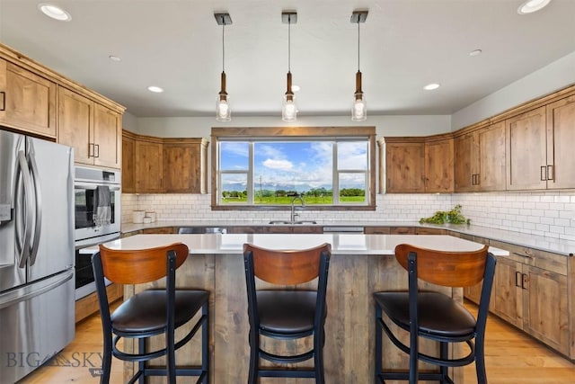 3483 Highline Rd, Manhattan, MT 59741 - kitchen with stainless steel appliances, a sink, a kitchen island, recessed lighting, and backsplash