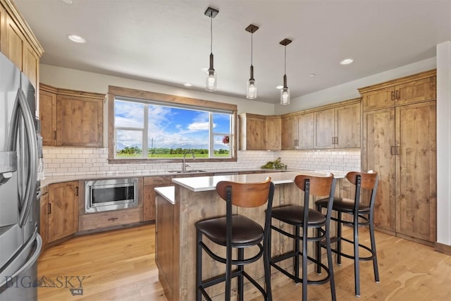 3483 Highline Rd, Manhattan, MT 59741 - kitchen featuring appliances with stainless steel finishes, a sink, light wood-style flooring, recessed lighting, and decorative backsplash