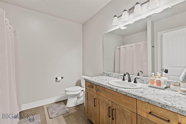 3483 Highline Rd, Manhattan, MT 59741 - full bathroom with wood finished floors, vanity, toilet, baseboards, and a shower with shower curtain