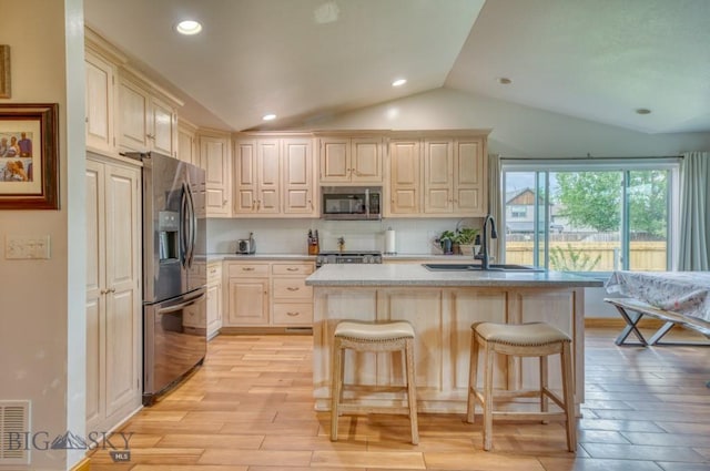 118 Clinton, Belgrade, MT 59714 - kitchen with stainless steel appliances, vaulted ceiling, light countertops, backsplash, and light wood-style flooring