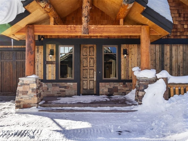 18 Upper Cascade Ridge Rd Unit 18, Big Sky, MT 59716 - snow covered property entrance featuring stone siding and covered porch