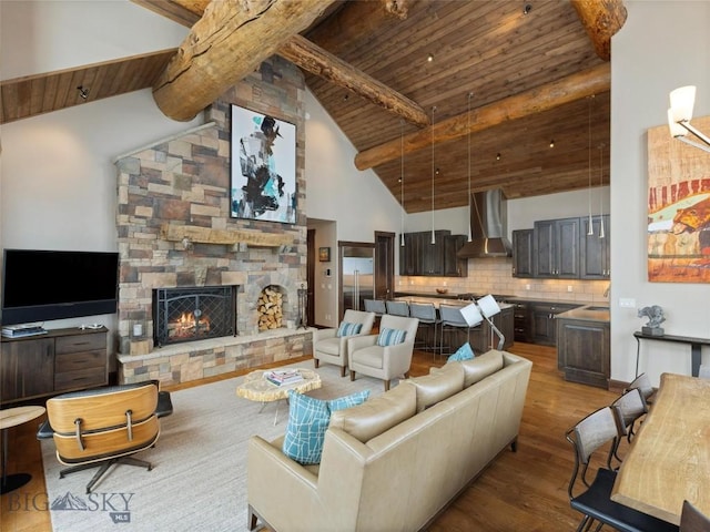 18 Upper Cascade Ridge Rd Unit 18, Big Sky, MT 59716 - living room with wood ceiling with exposed beams, wood finished floors, a stone fireplace, and high vaulted ceiling