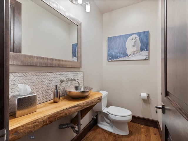 18 Upper Cascade Ridge Rd Unit 18, Big Sky, MT 59716 - half bathroom with toilet, a sink, baseboards, wood finished floors, and decorative backsplash