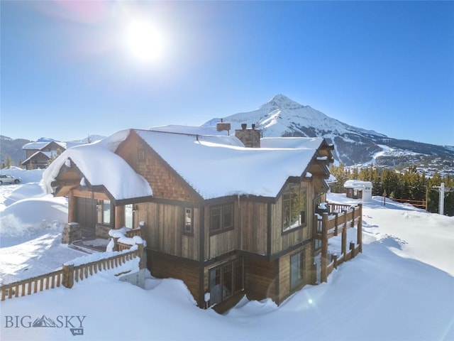 18 Upper Cascade Ridge Rd Unit 18, Big Sky, MT 59716 - view of snow covered exterior featuring a chimney and a mountain view