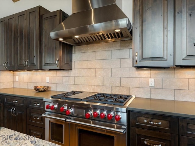 18 Upper Cascade Ridge Rd Unit 18, Big Sky, MT 59716 - kitchen featuring range with two ovens, wall chimney exhaust hood, dark brown cabinetry, backsplash, and light countertops