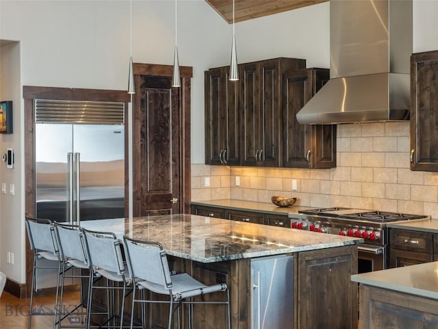 18 Upper Cascade Ridge Rd Unit 18, Big Sky, MT 59716 - kitchen featuring wall chimney range hood, high quality appliances, dark brown cabinets, tasteful backsplash, and vaulted ceiling
