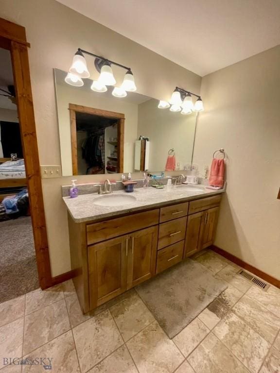 121 Ridge Ct, Dillon, MT 59725 - bathroom with double vanity, ensuite bath, baseboards, and a spacious closet
