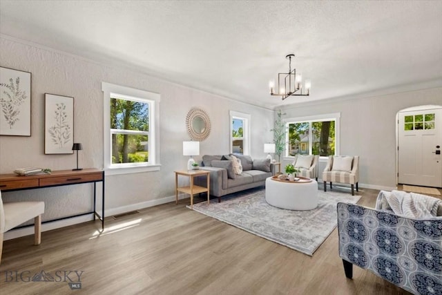 643 Parkhill, Billings, MT 59102 - living area featuring a chandelier, wood finished floors, baseboards, and crown molding