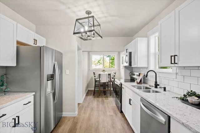 643 Parkhill, Billings, MT 59102 - kitchen featuring stainless steel appliances, a sink, white cabinets, a chandelier, and decorative backsplash