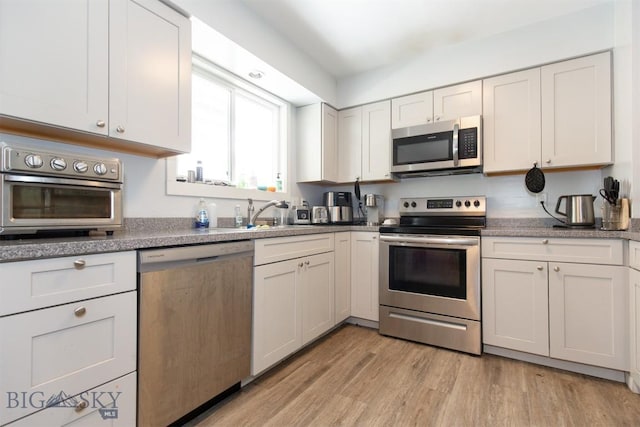 504 N 19th Ave, Bozeman, MT 59718 - kitchen featuring appliances with stainless steel finishes, light wood-type flooring, white cabinets, and a sink