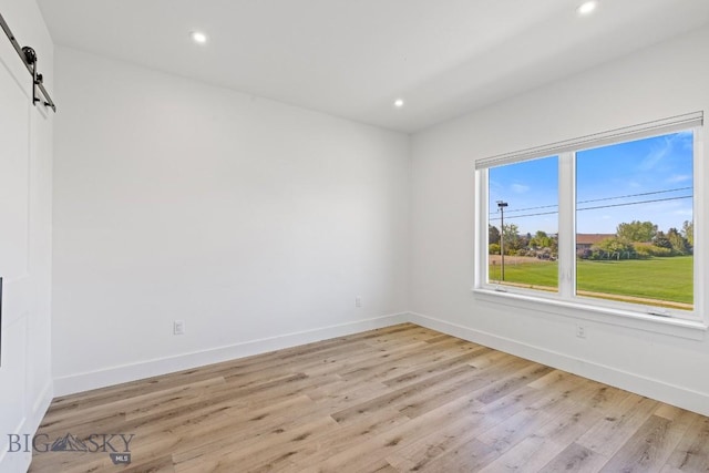 1704 W Lincoln Unit 5B, Bozeman, MT 59715 - empty room with a barn door, light wood-style flooring, and recessed lighting