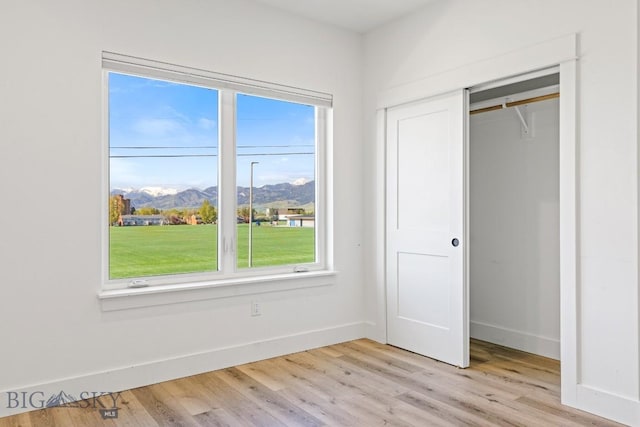 1704 W Lincoln Unit 5B, Bozeman, MT 59715 - unfurnished bedroom with a mountain view, baseboards, light wood-type flooring, and a closet