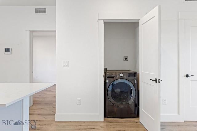 1704 W Lincoln Unit 5B, Bozeman, MT 59715 - washroom with washer / clothes dryer, light wood-type flooring, and baseboards