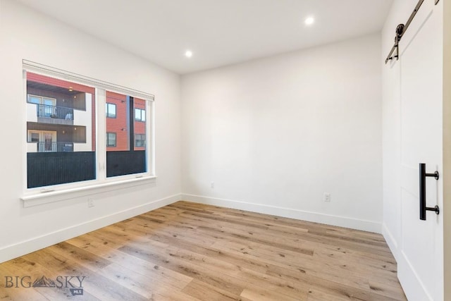 1704 W Lincoln Unit 5B, Bozeman, MT 59715 - empty room with a barn door, light wood-style floors, and recessed lighting