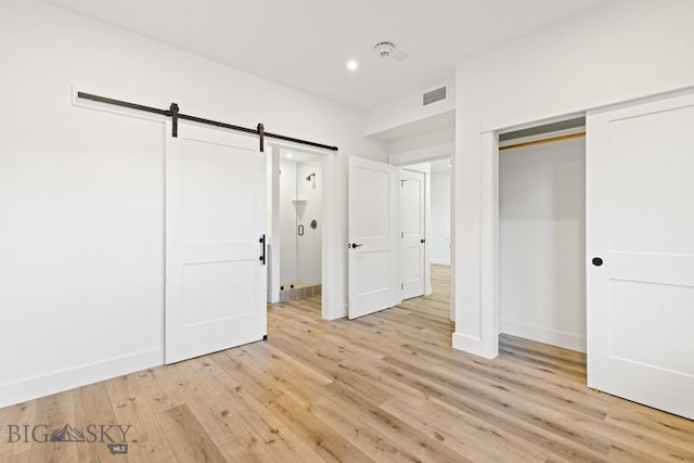1704 W Lincoln Unit 5B, Bozeman, MT 59715 - unfurnished bedroom featuring light wood-style floors, a barn door, a closet, and recessed lighting