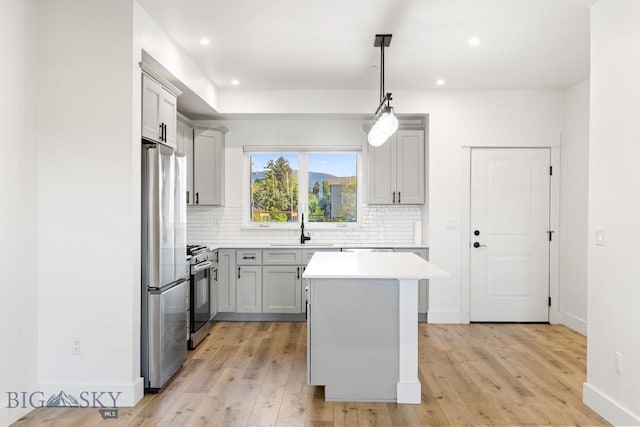 1704 W Lincoln Unit 5B, Bozeman, MT 59715 - kitchen featuring appliances with stainless steel finishes, a sink, backsplash, light wood finished floors, and recessed lighting