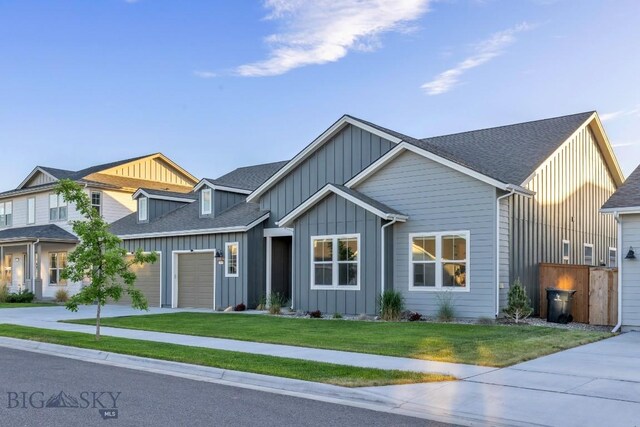 1609 Wyatt Earp Ct, Belgrade, MT 59714 - view of front of property featuring board and batten siding, driveway, a front lawn, roof with shingles, and an attached garage