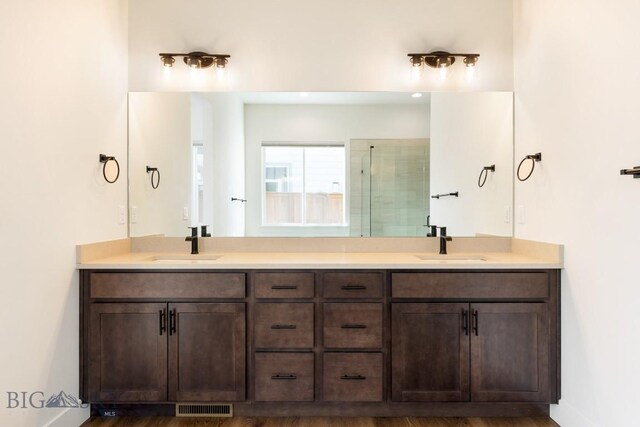 1609 Wyatt Earp Ct, Belgrade, MT 59714 - bathroom featuring double vanity, a tile shower, and baseboards