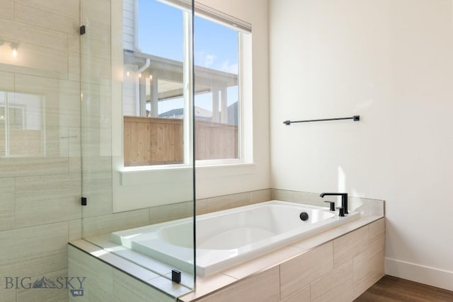 1609 Wyatt Earp Ct, Belgrade, MT 59714 - full bath with a garden tub, wood finished floors, and a tile shower