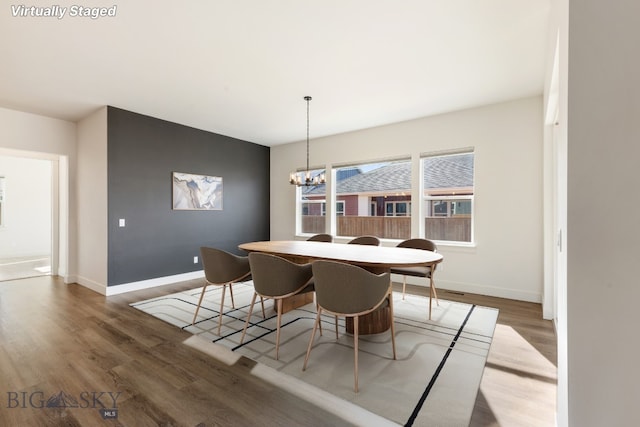 1609 Wyatt Earp Ct, Belgrade, MT 59714 - dining area with wood finished floors, a chandelier, and baseboards