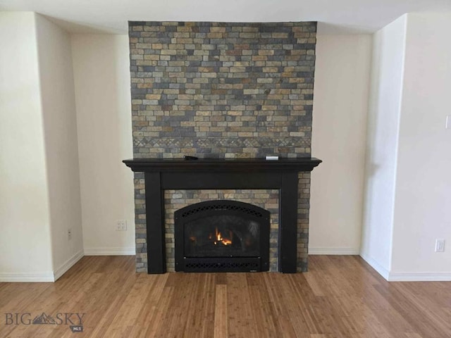 4442 Alexander, Bozeman, MT 59718 - detailed view of wood finished floors, a large fireplace, and baseboards