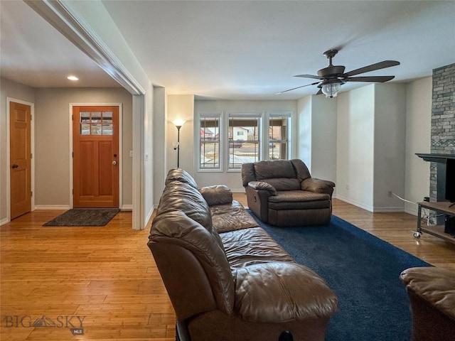 4442 Alexander, Bozeman, MT 59718 - living area featuring a ceiling fan, light wood-type flooring, baseboards, and a stone fireplace