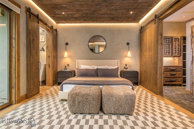 5933 Monforton School Rd, Bozeman, MT 59718 - bedroom with a barn door and wood finished floors
