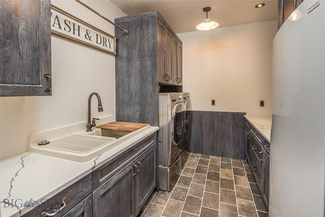 5933 Monforton School Rd, Bozeman, MT 59718 - washroom with washing machine and dryer, cabinet space, and dark stone finish floors