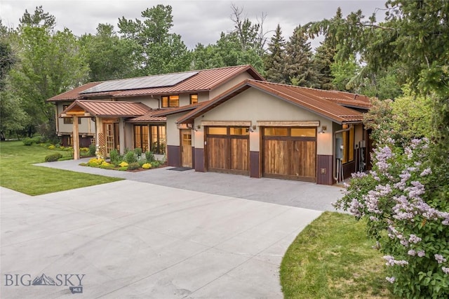 5933 Monforton School Rd, Bozeman, MT 59718 - view of front of property with concrete driveway, a standing seam roof, solar panels, an attached garage, and a front lawn