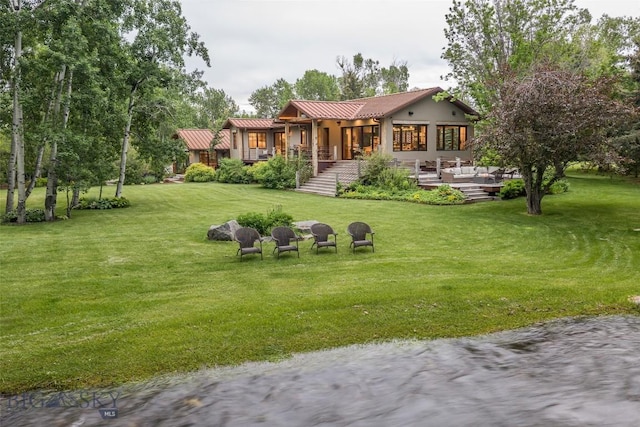 5933 Monforton School Rd, Bozeman, MT 59718 - back of property with stucco siding, a deck with water view, and a lawn