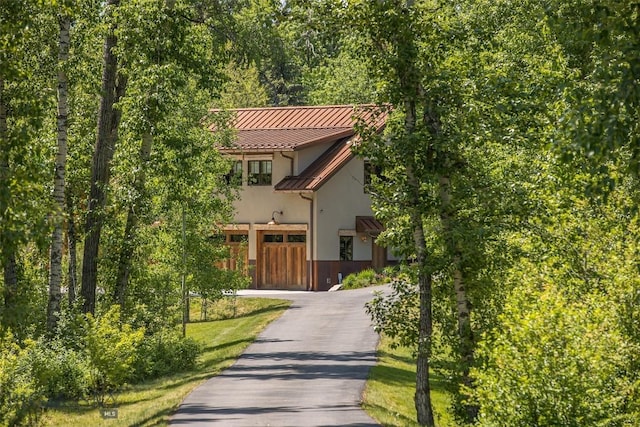 5933 Monforton School Rd, Bozeman, MT 59718 - view of front of house with stucco siding, a standing seam roof, metal roof, and driveway