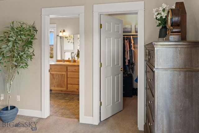 126 Pathfinder Trl, Bozeman, MT 59718 - bedroom featuring a walk in closet, light carpet, a closet, and ensuite bath