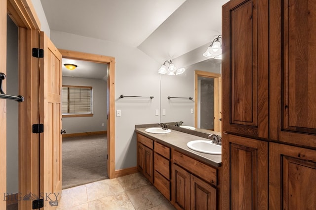 1025 Advance Dr, Bozeman, MT 59718 - full bathroom with double vanity, tile patterned flooring, and vaulted ceiling