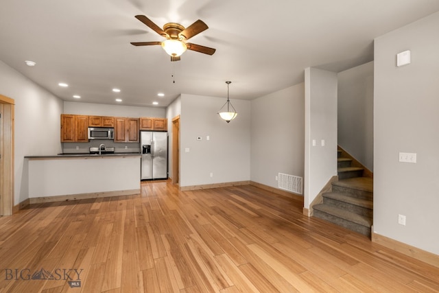 1025 Advance Dr, Bozeman, MT 59718 - unfurnished living room featuring recessed lighting, light wood-style flooring, ceiling fan, and stairway