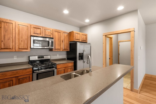 1025 Advance Dr, Bozeman, MT 59718 - kitchen featuring stainless steel appliances, light wood finished floors, dark countertops, recessed lighting, and brown cabinetry