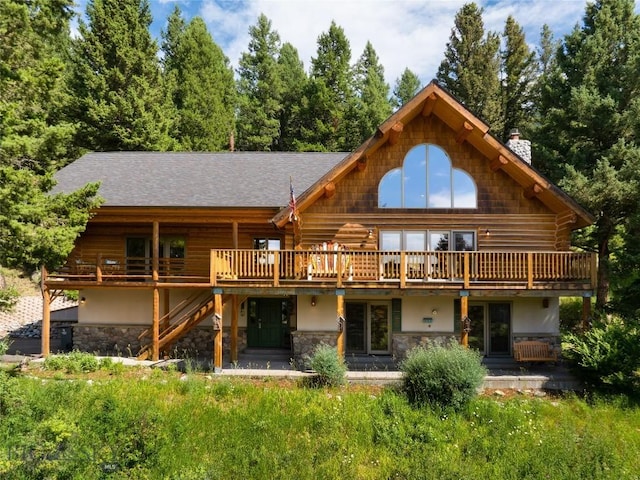2415 Crazy Horse Rd, Big Sky, MT 59716 - back of property with a chimney, stone siding, a deck, and log exterior