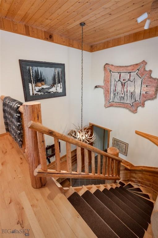 2415 Crazy Horse Rd, Big Sky, MT 59716 - staircase with wood ceiling, wood finished floors, and a chandelier