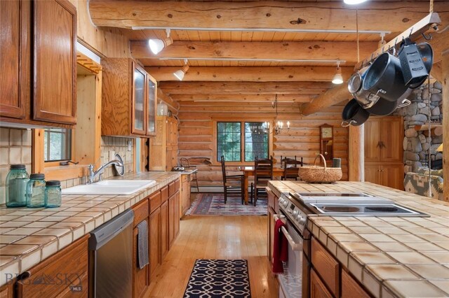 2415 Crazy Horse Rd, Big Sky, MT 59716 - kitchen featuring tile countertops, log walls, stainless steel appliances, a sink, and light wood finished floors