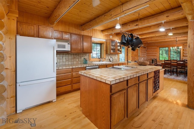 2415 Crazy Horse Rd, Big Sky, MT 59716 - kitchen with white appliances, wood ceiling with exposed beams, tile counters, light wood-style floors, and brown cabinetry