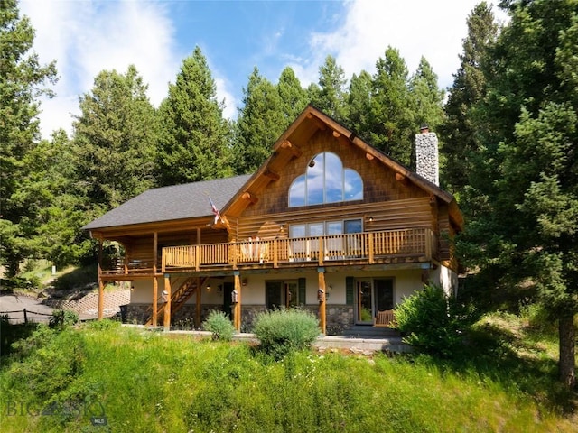 2415 Crazy Horse Rd, Big Sky, MT 59716 - rear view of property with a chimney, log exterior, a wooden deck, and stairs