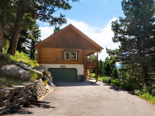 2415 Crazy Horse Rd, Big Sky, MT 59716 - view of property exterior featuring asphalt driveway, stairs, a garage, stone siding, and stucco siding