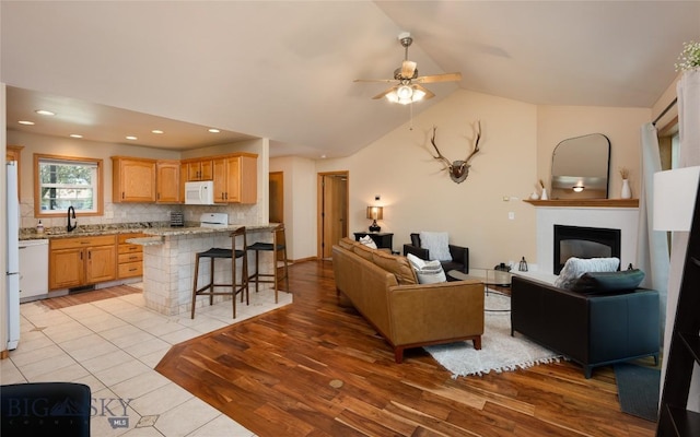 56 Green Belt Dr, Belgrade, MT 59714 - living room with ceiling fan, a glass covered fireplace, lofted ceiling, light wood-type flooring, and recessed lighting