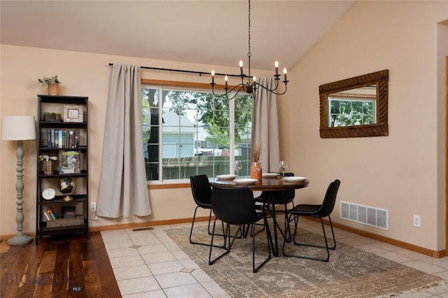 56 Green Belt Dr, Belgrade, MT 59714 - tiled dining room with a chandelier, vaulted ceiling, and baseboards