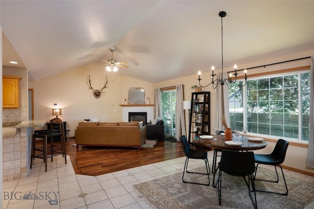 56 Green Belt Dr, Belgrade, MT 59714 - dining area with ceiling fan, lofted ceiling, a fireplace, and light wood-style flooring