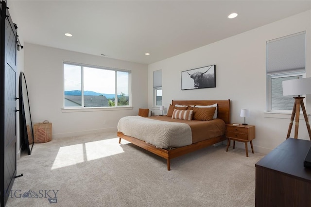 810 Butler Crk, Belgrade, MT 59714 - bedroom featuring a barn door, light colored carpet, and recessed lighting