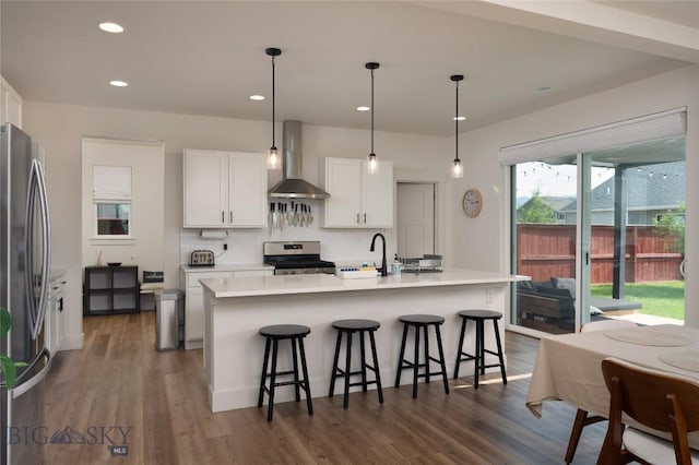 810 Butler Crk, Belgrade, MT 59714 - kitchen with wall chimney exhaust hood, appliances with stainless steel finishes, white cabinetry, a breakfast bar area, and light countertops