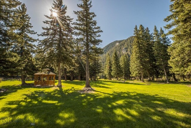 48042 Gallatin Rd, Big Sky, MT 59730 - view of home's community featuring a lawn, a gazebo, a view of trees, and a mountain view